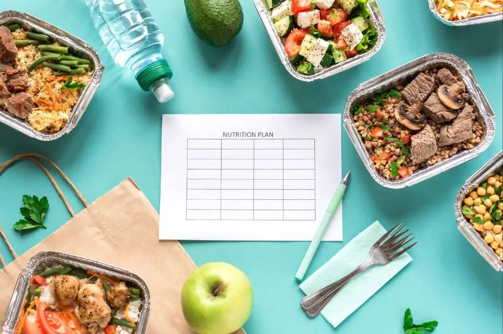 Nutrition log surrounded by healthy foods for nutrition coaching and elevated fitness